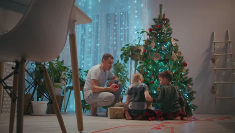 Samya-father-and-two-sons-together-decorate-the-Christmas-tree-for-the-new-year-and-Christmas.-New-Year's-decorations.-High-quality-4k-footage